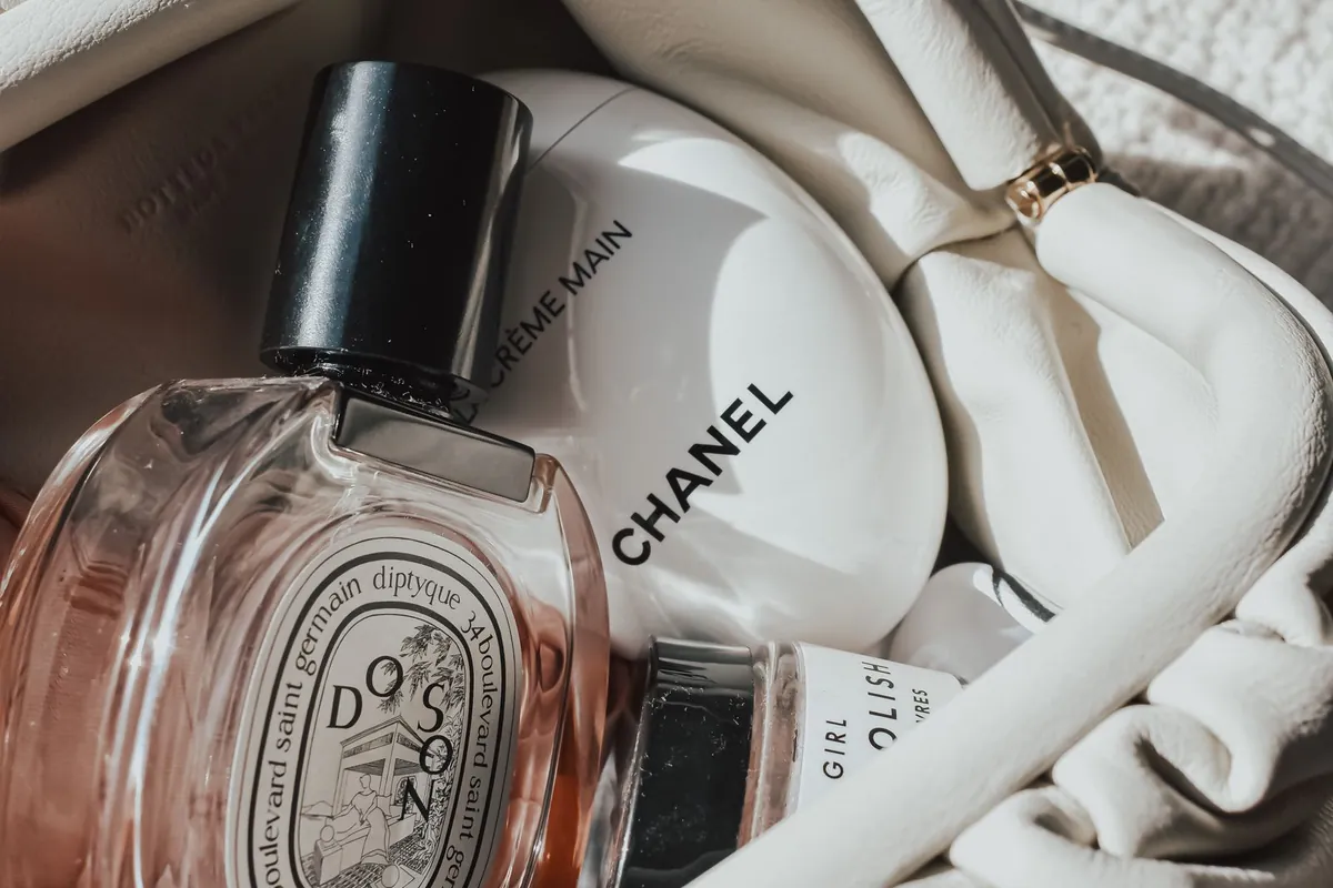 Perfume and cosmetics arranged inside a stylish handbag