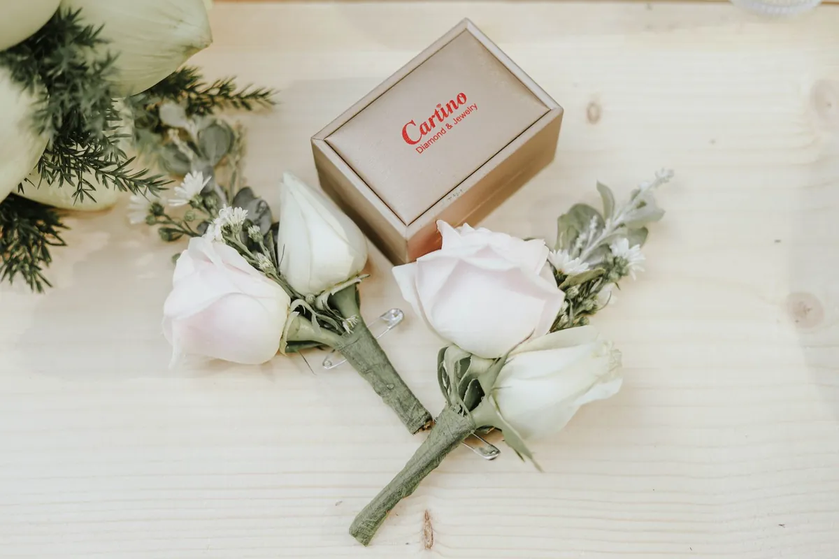 Delicate jewelry displayed in a gift box beside soft flowers